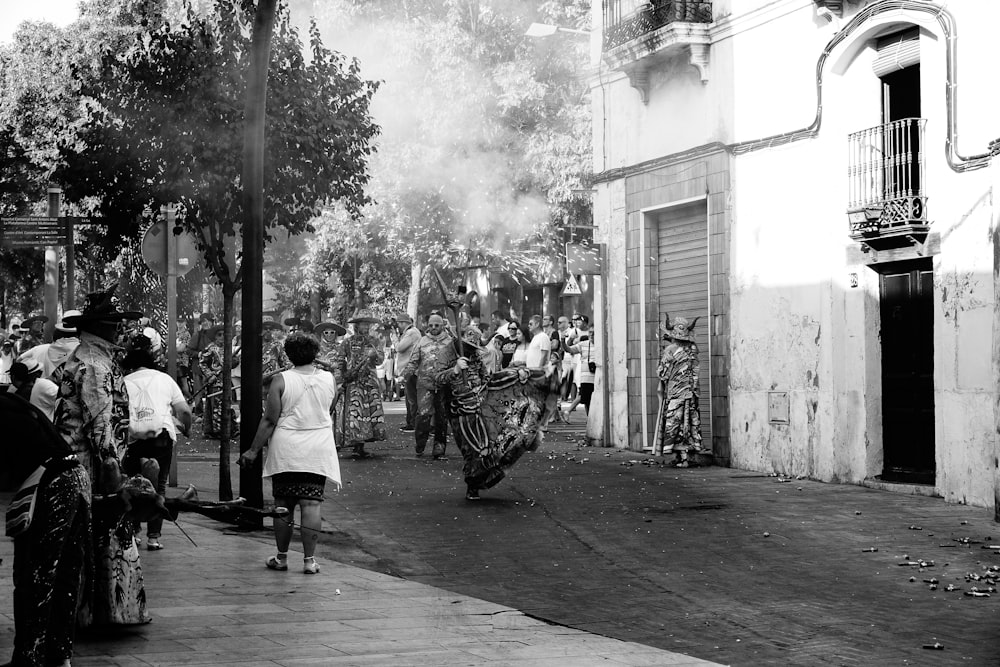 Un grupo de personas caminando por una calle junto a edificios altos