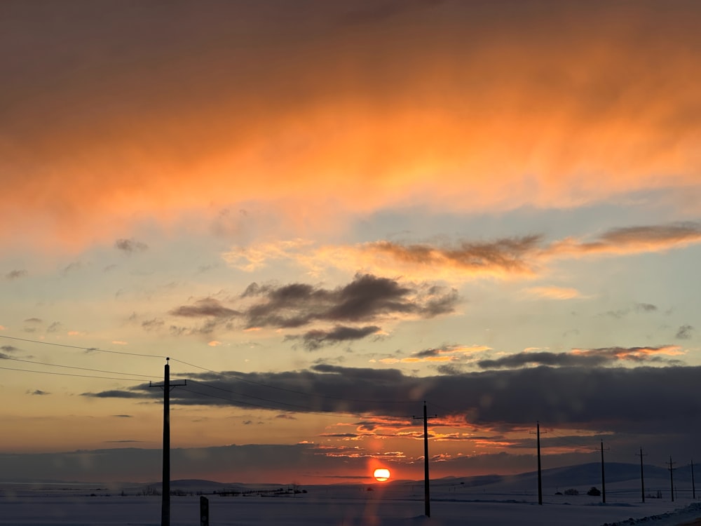 Die Sonne geht über einem verschneiten Feld unter