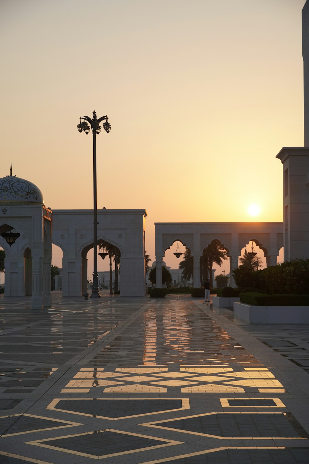 the sun is setting behind a white building