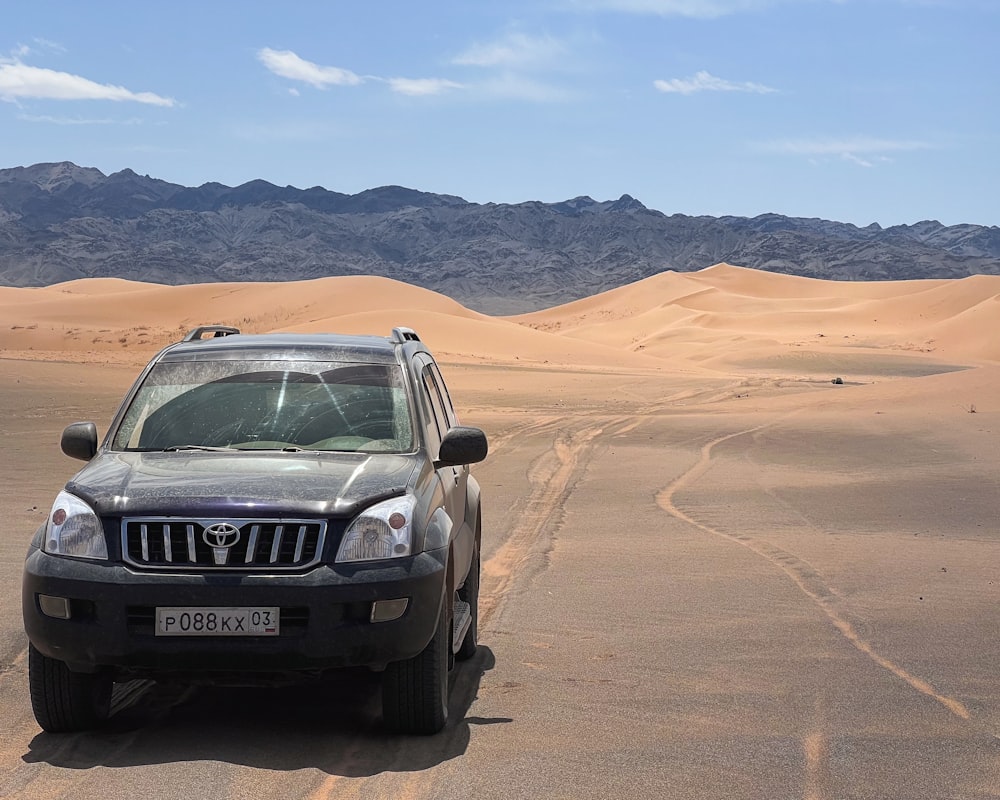 Um jipe está estacionado no meio do deserto