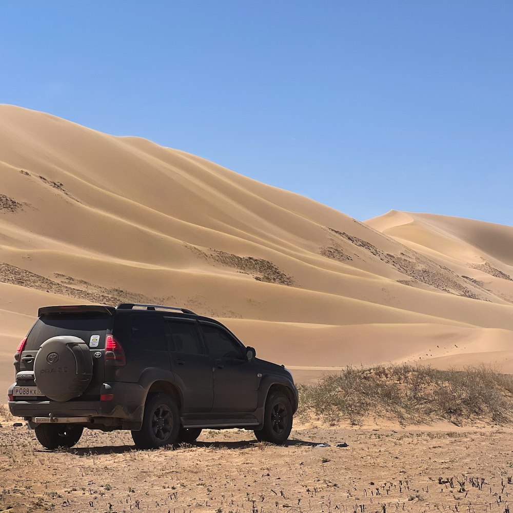 사막 한가운데에 SUV 한 대가 주차되어 있습니다