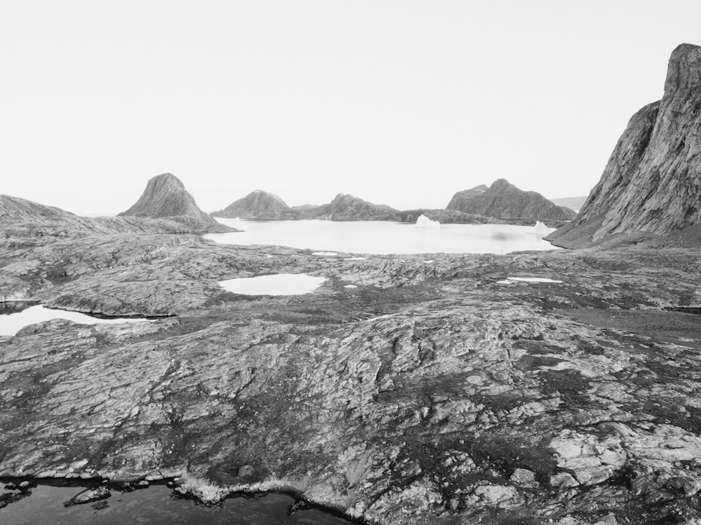 a black and white photo of mountains and a body of water