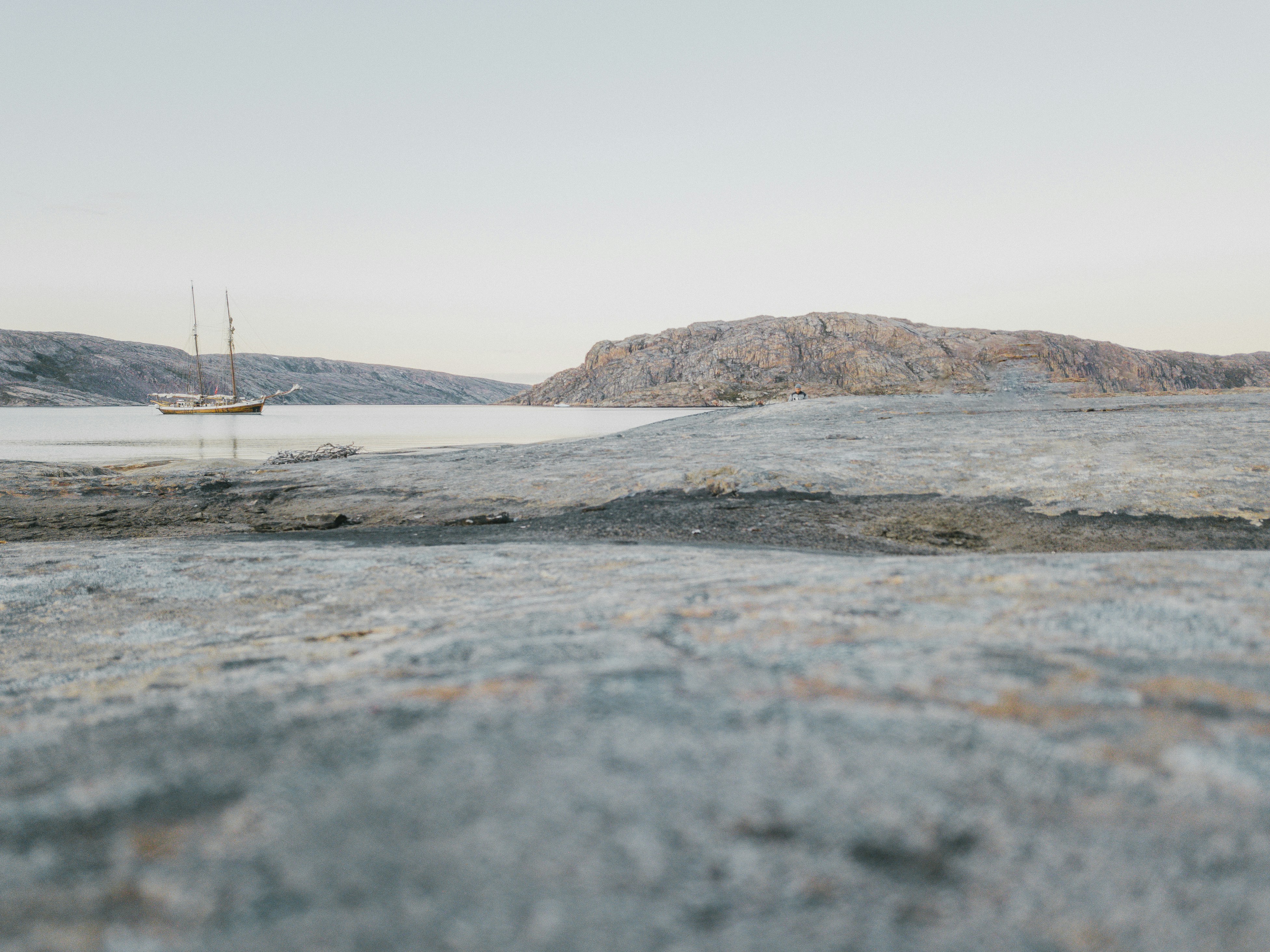 a boat floating on top of a body of water, 
