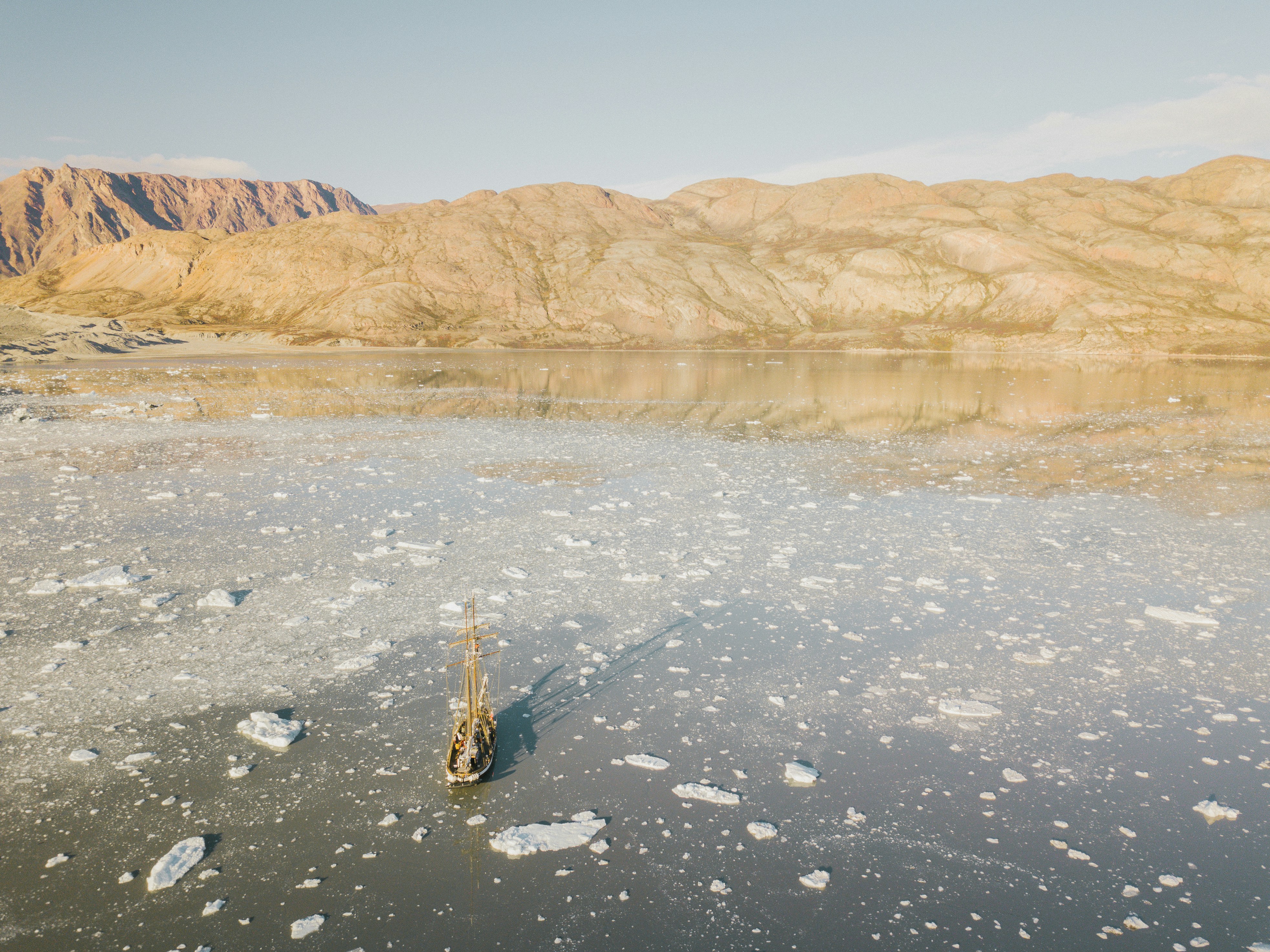 a boat floating on top of a lake surrounded by mountains