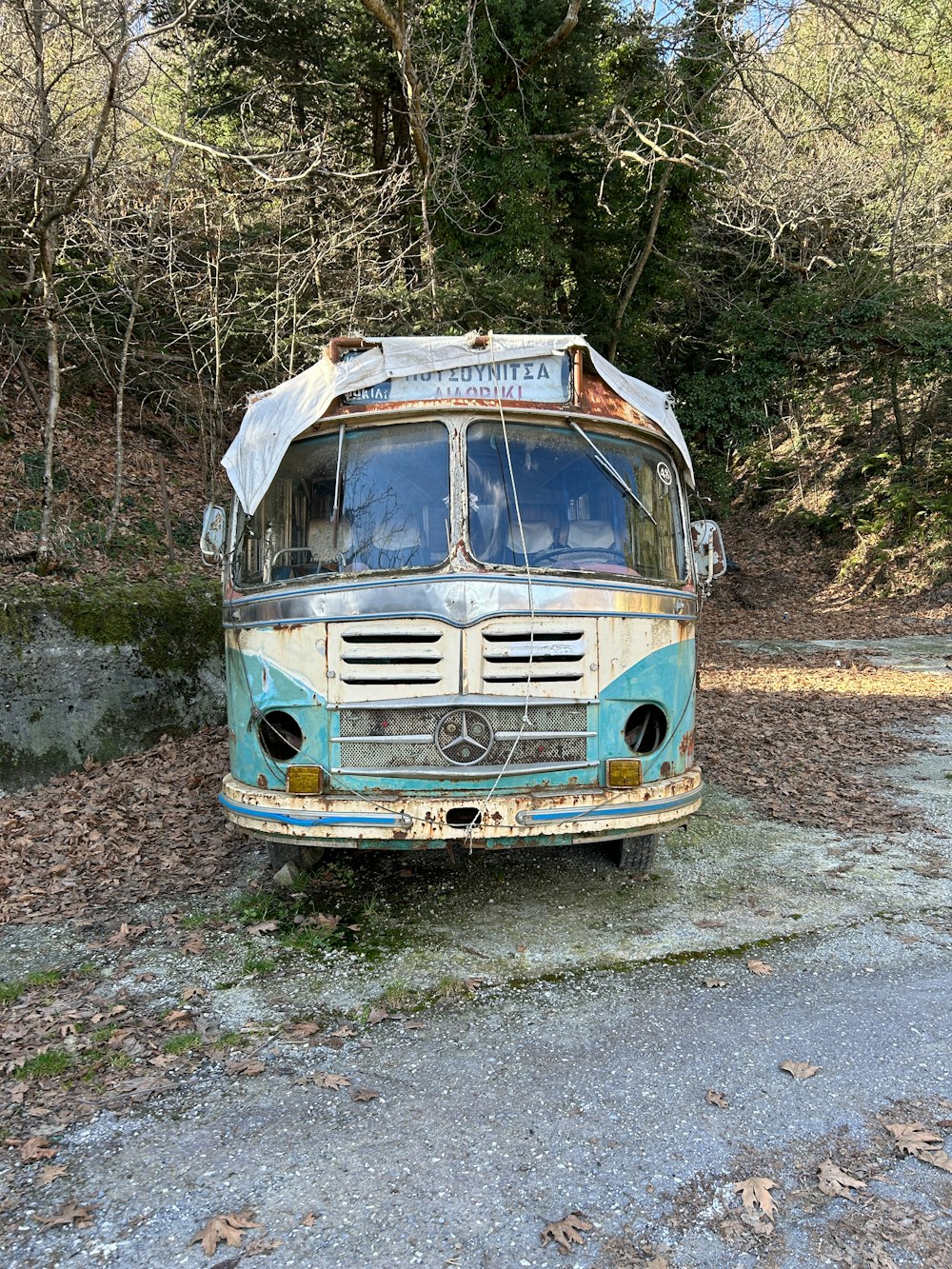 an old bus is parked in the woods