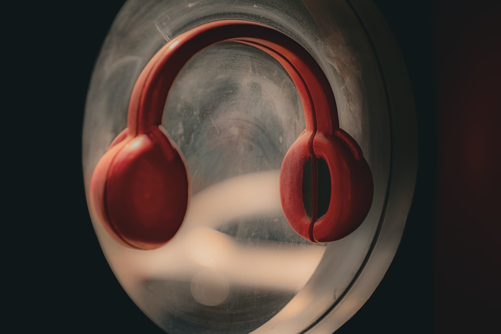 a pair of red headphones sitting on top of a mirror