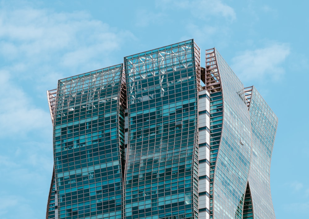 a very tall glass building with a sky background