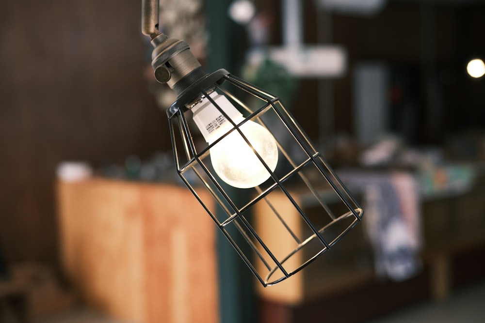 a metal cage hanging from a light fixture