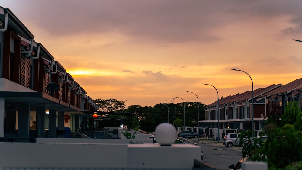 a city street at sunset with buildings and street lights