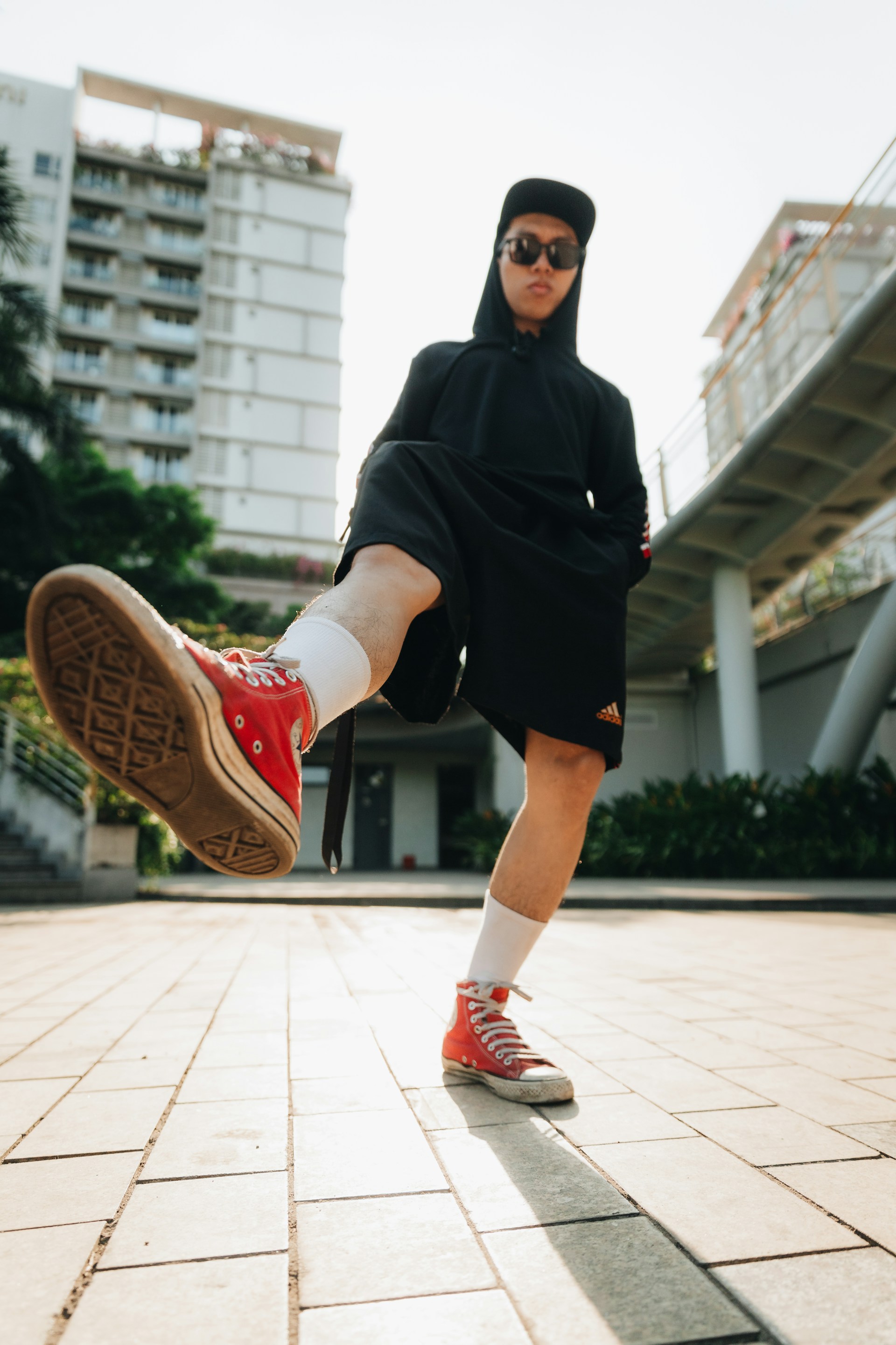 a person wearing red shoes and a black outfit