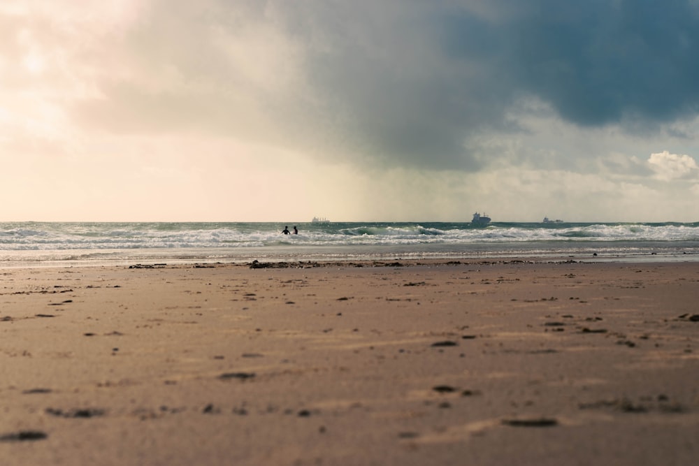 a person walking on a beach with a surfboard