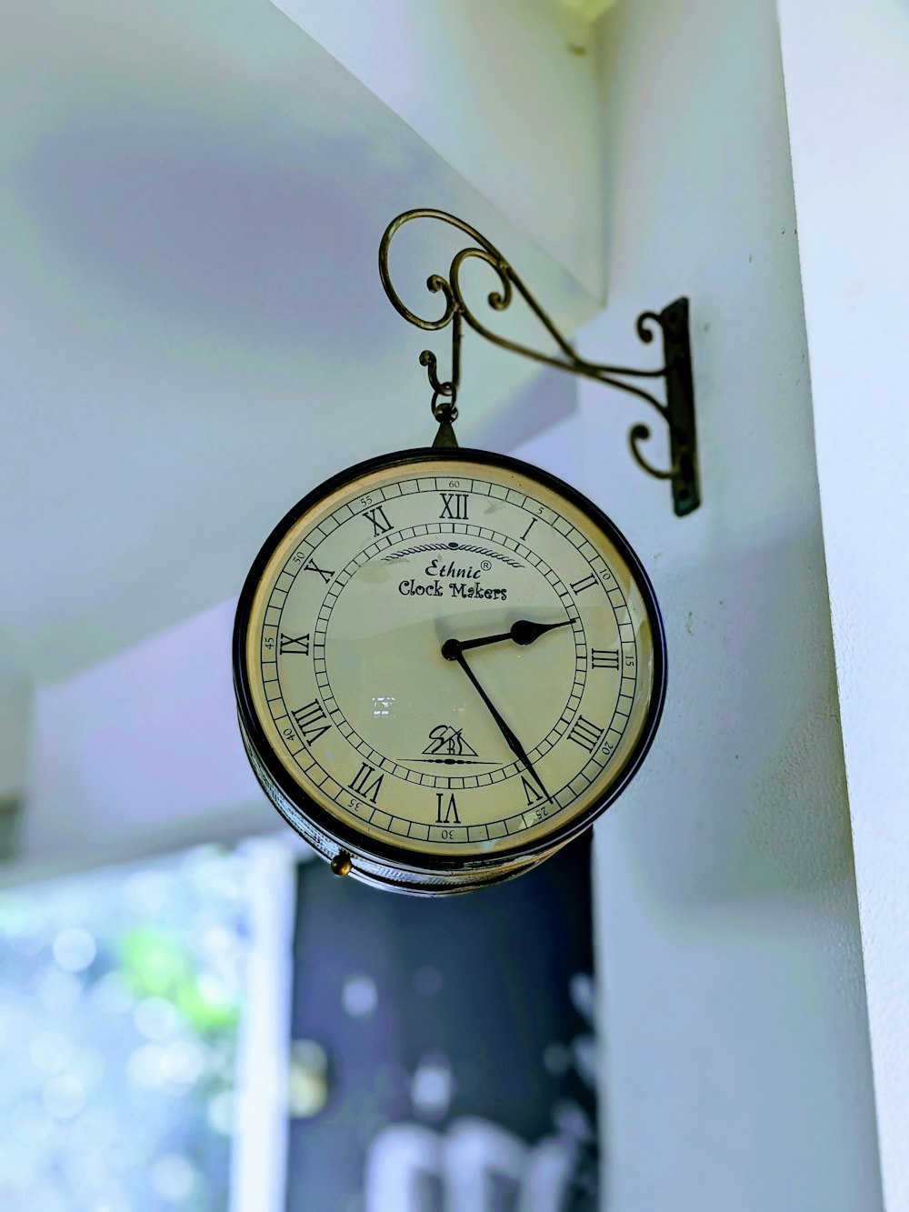 a clock hanging from the side of a wall