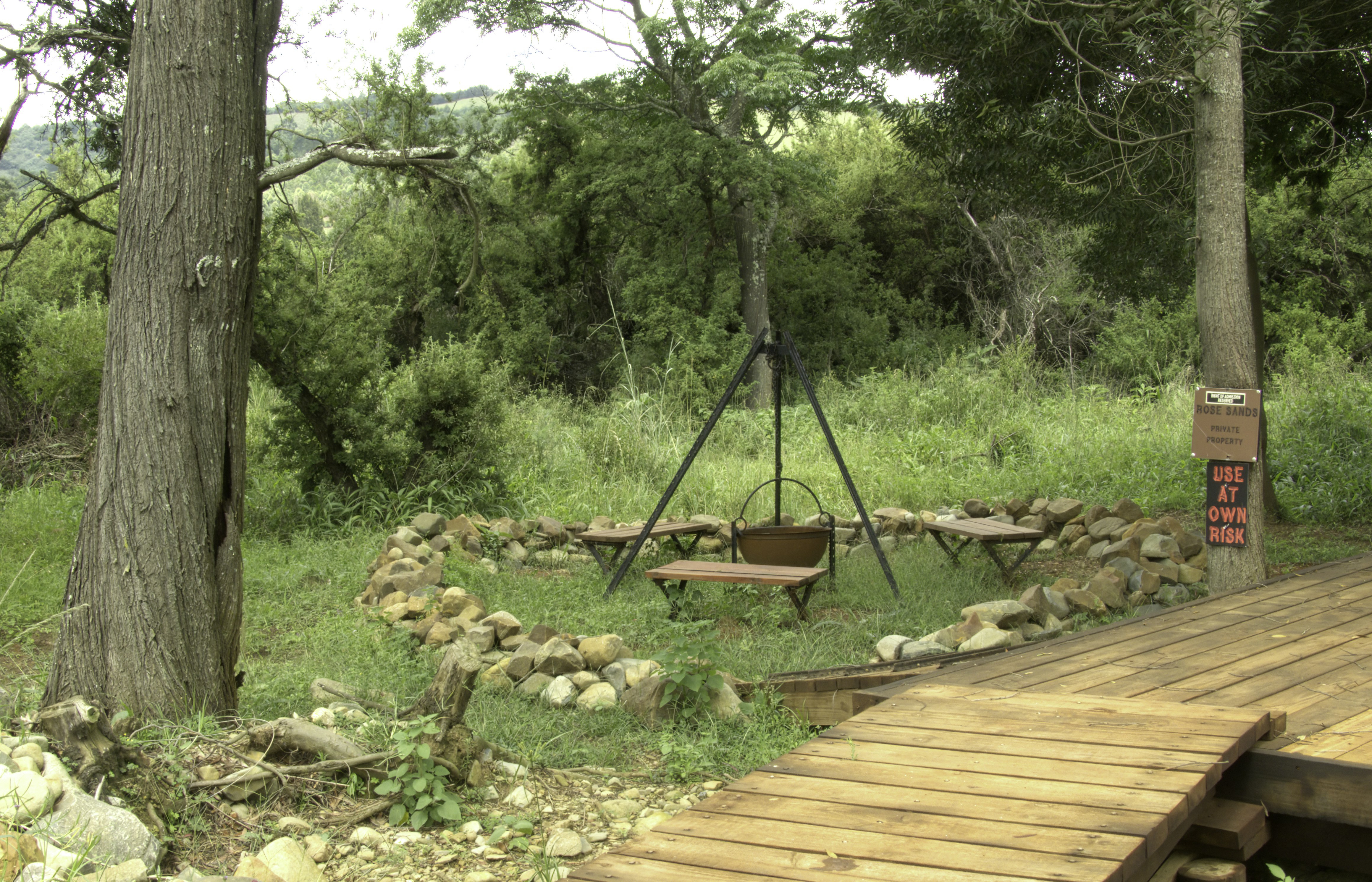 A wooden deck with a swing in the woods