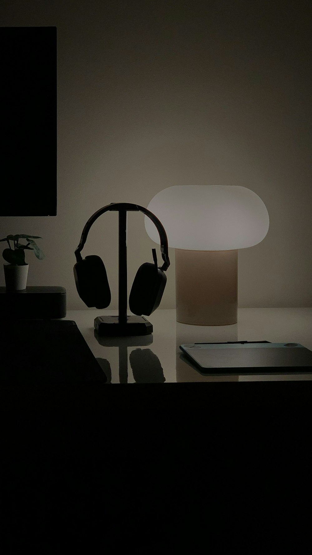 a table with a lamp and headphones on it