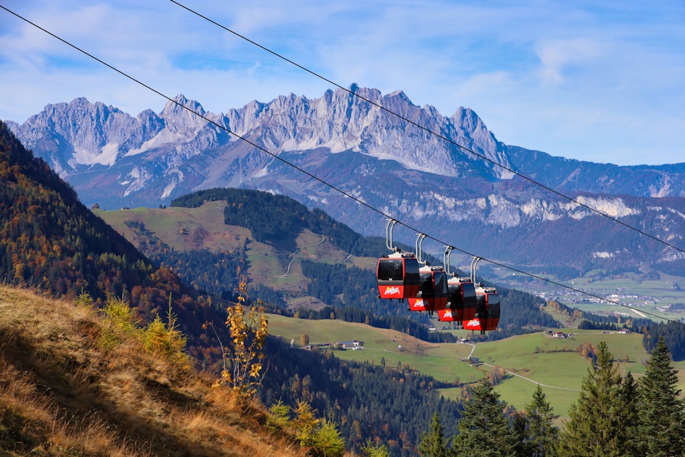 a couple of red gondolas hanging from a wire