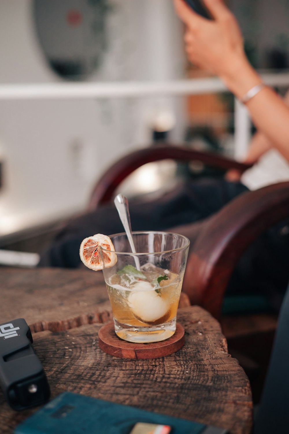 a glass filled with a drink sitting on top of a wooden table