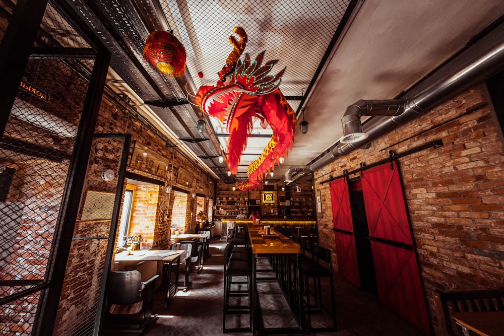 a restaurant with brick walls and a red dragon hanging from the ceiling