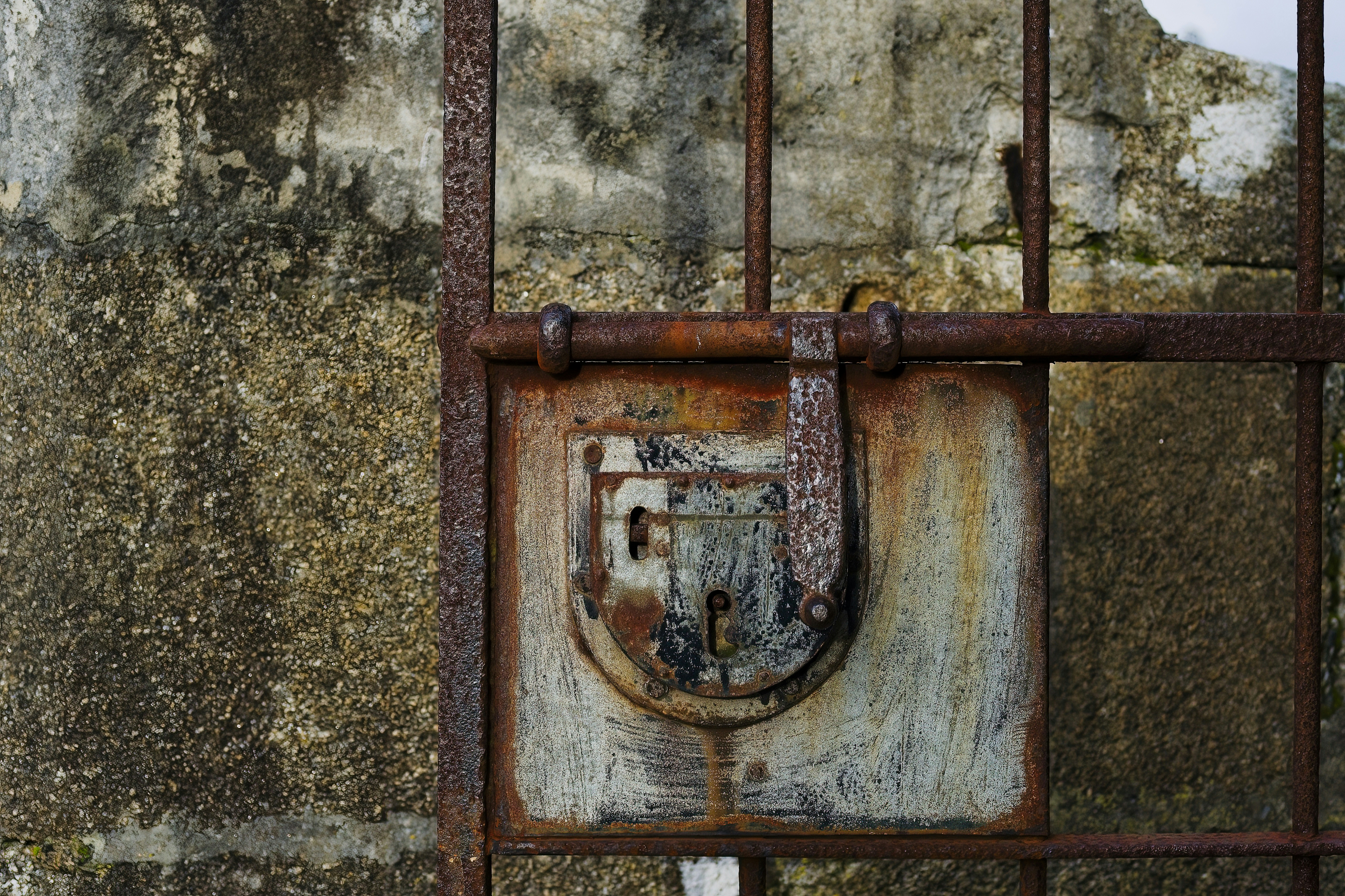 a rusted iron gate with a padlock on it