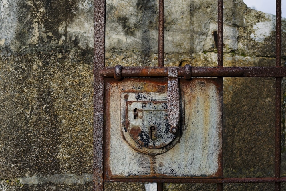 a rusted iron gate with a padlock on it