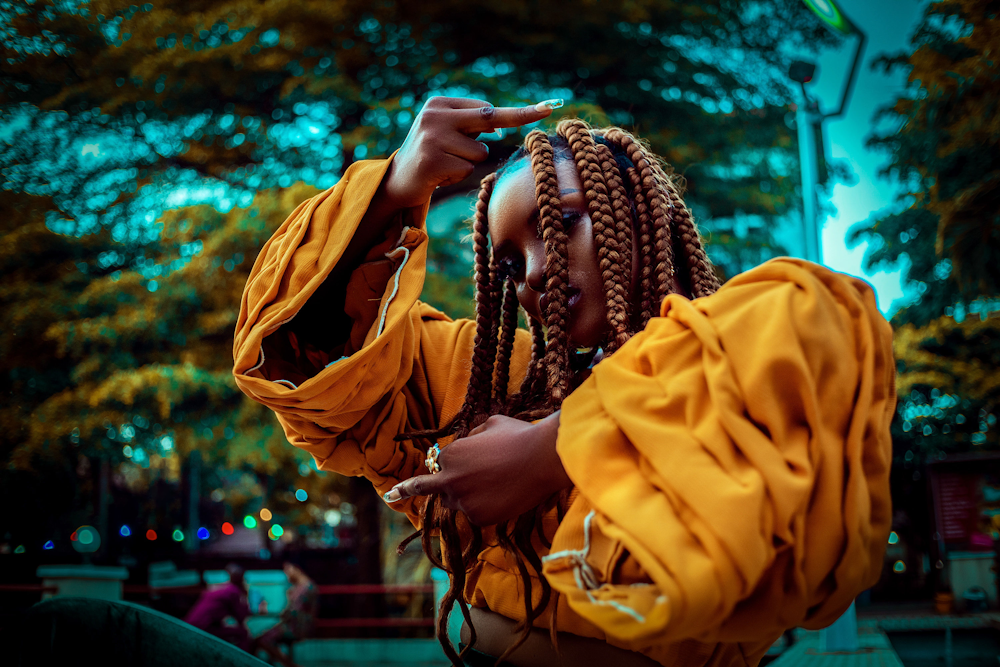 a woman with dreadlocks and a yellow shirt