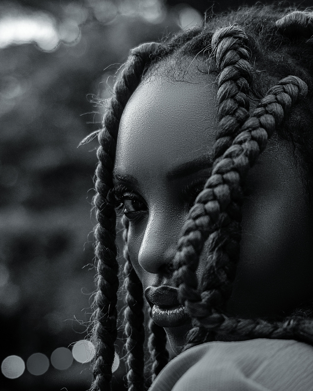 a black and white photo of a woman with dreadlocks