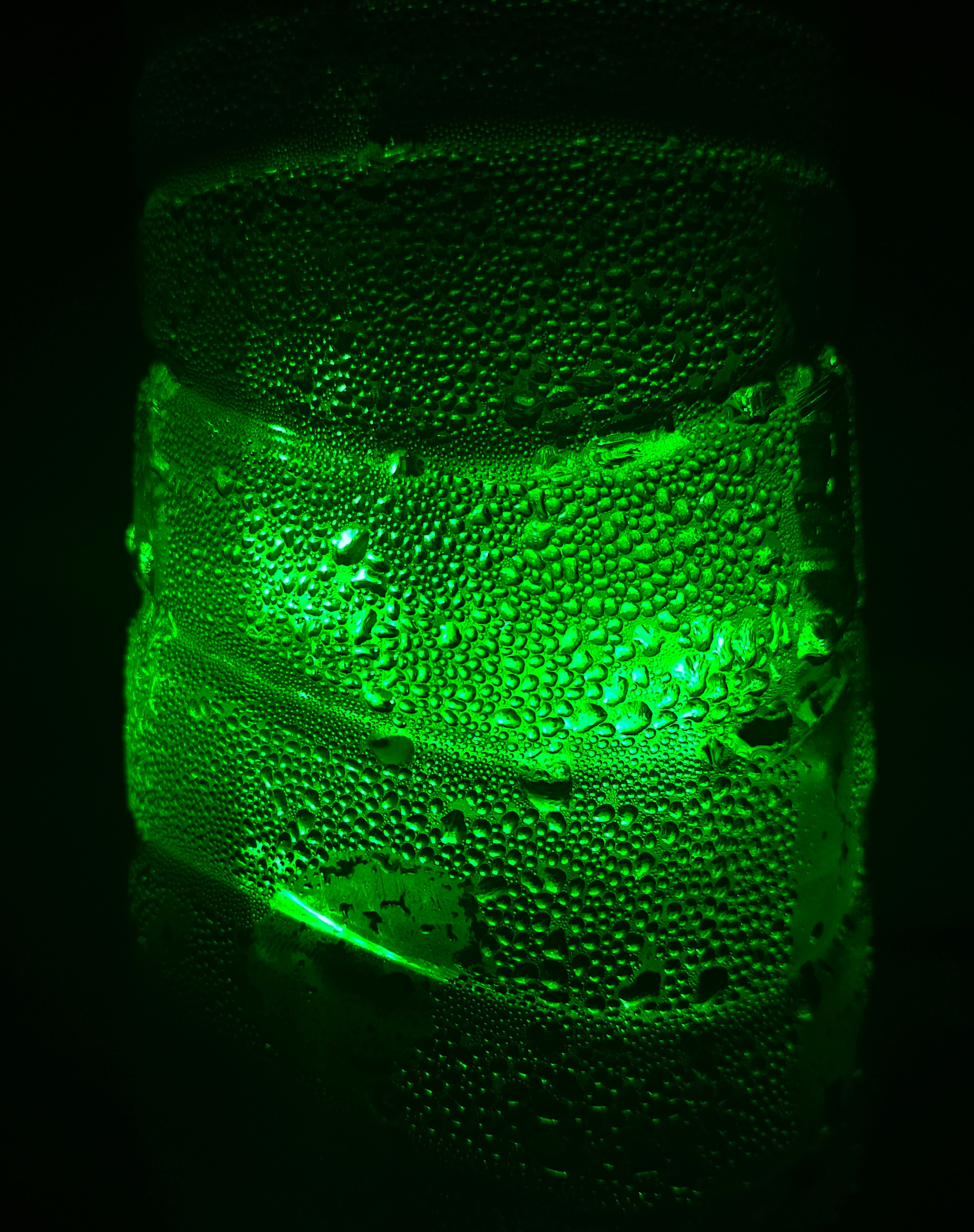 Close-up of condensation forming on a cold bottle surface, cool blue tones, sharp macro photography, bright studio light