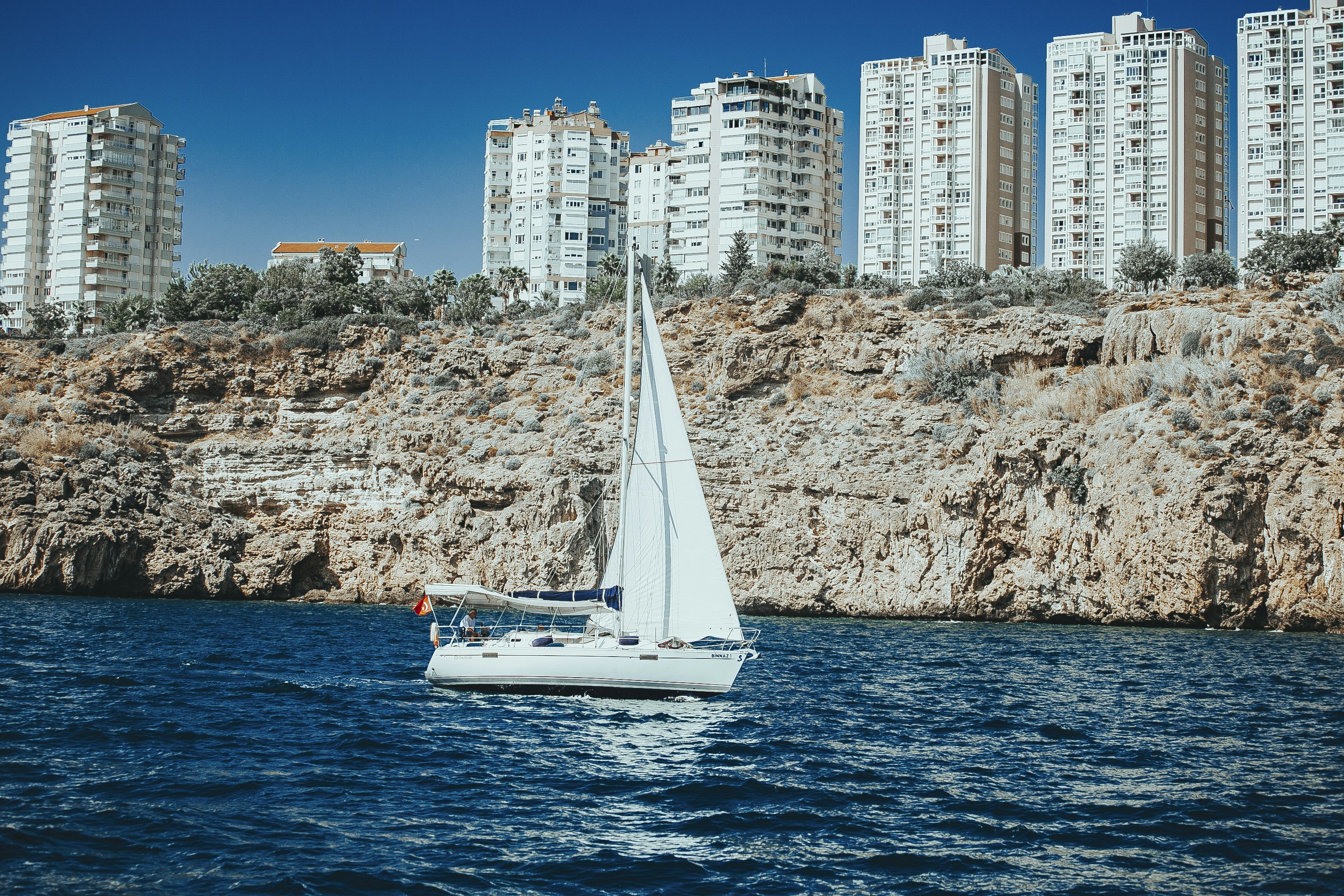 Un velero en un cuerpo de agua cerca de una ciudad