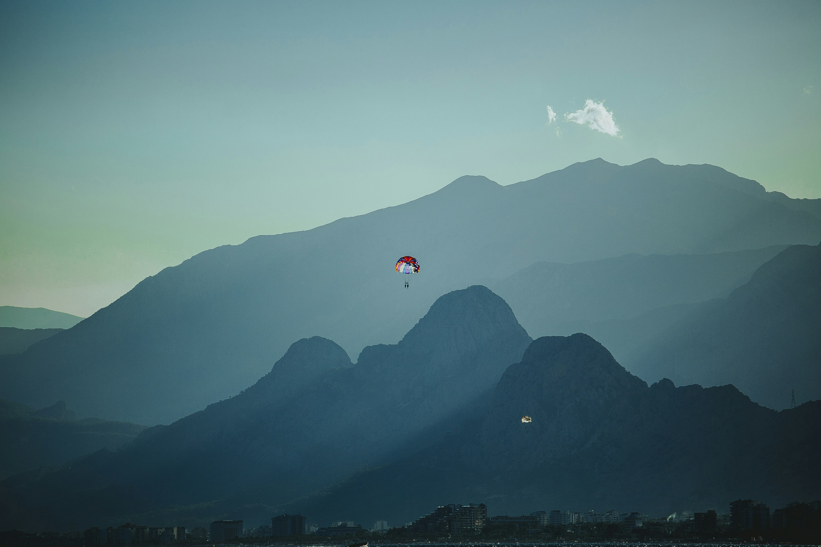 una persona para navegar en el océano con montañas en el fondo