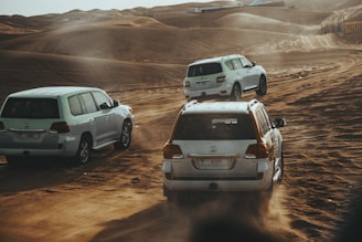 a group of cars driving on a dirt road