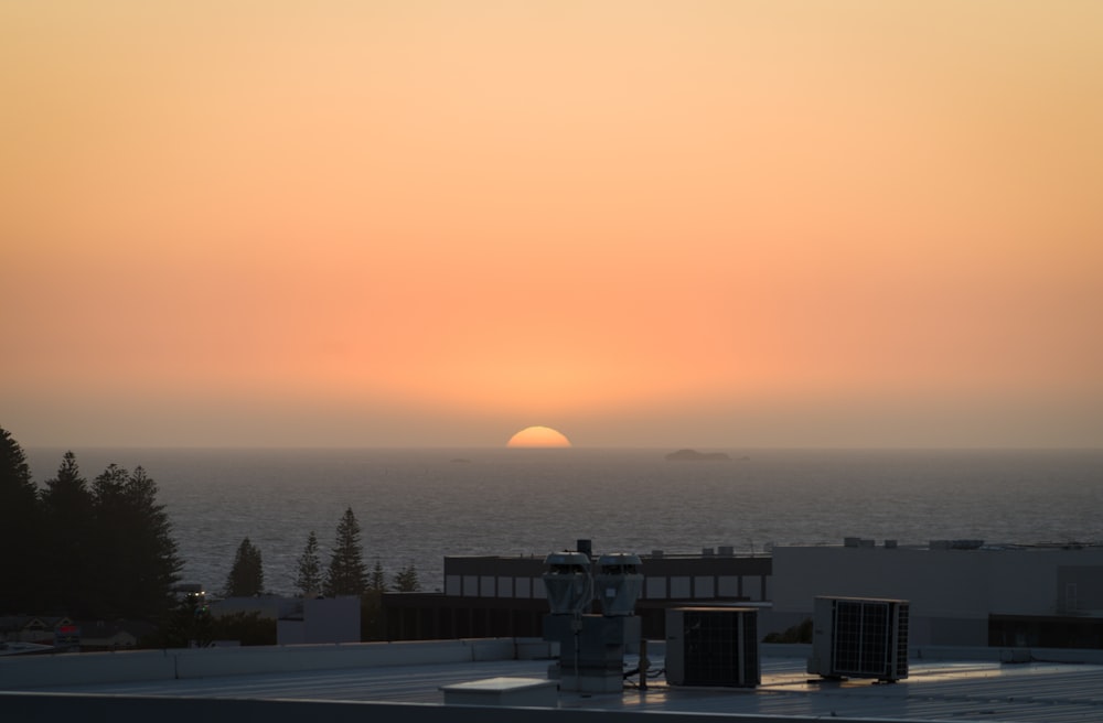 the sun is setting over the horizon of the ocean