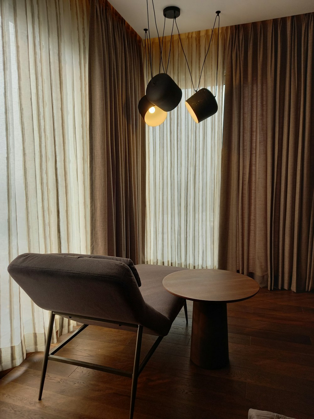a room with a table, chair and two lamps