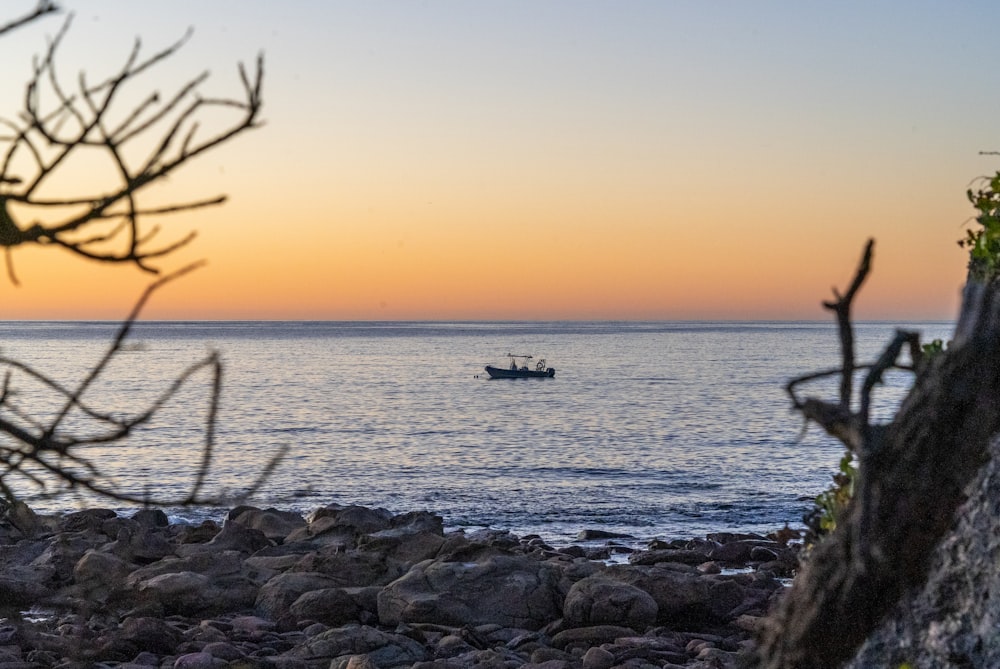 a boat is out on the water at sunset