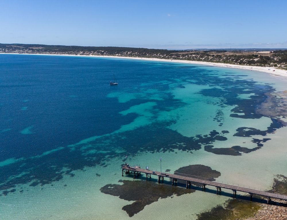 an aerial view of a beach with a pier