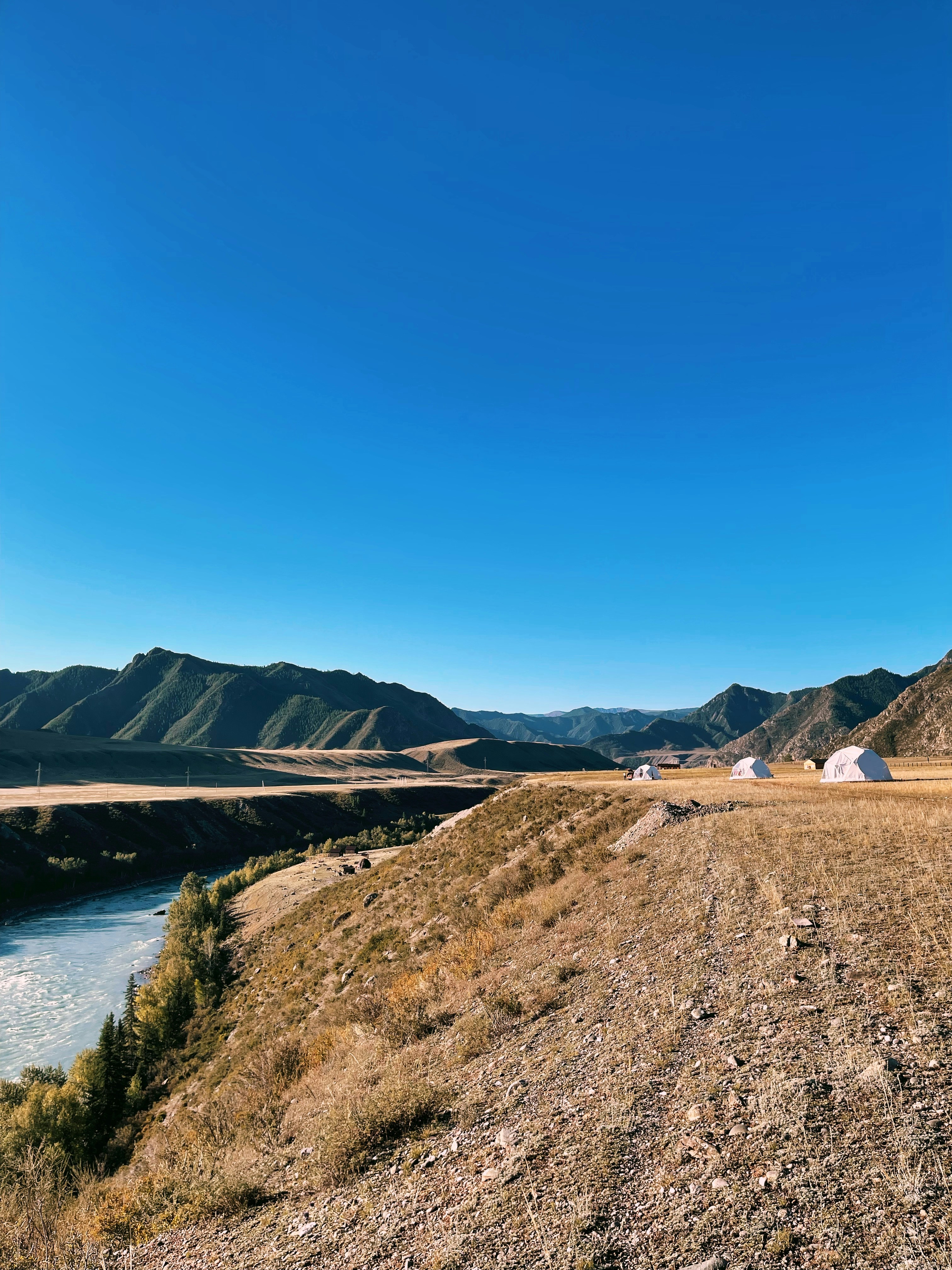 a view of a river and mountains from a hill