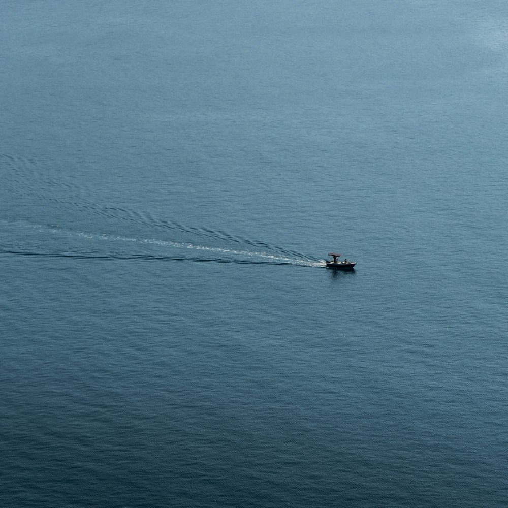 a small boat in the middle of a large body of water