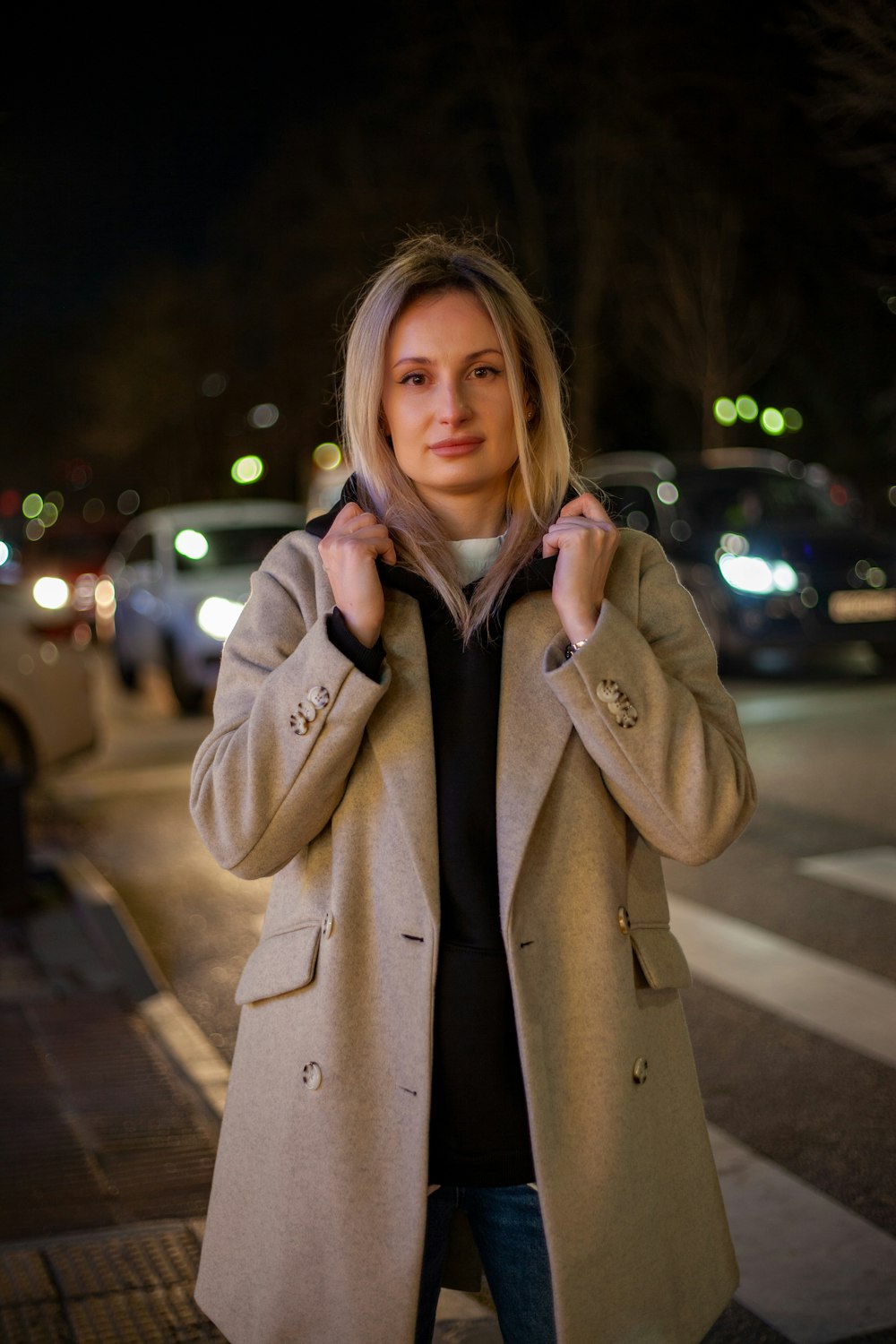 a woman in a coat is standing on the street