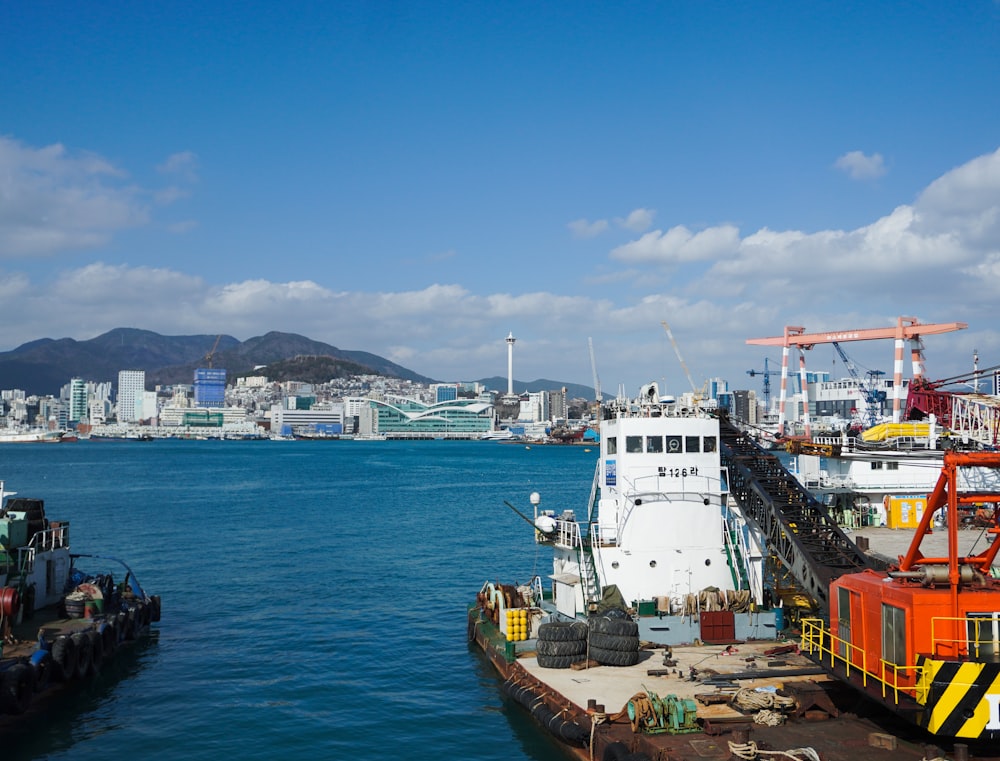 a boat docked in a harbor with a city in the background