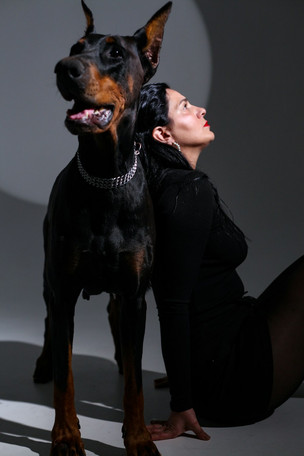 a woman laying on the ground next to a dog