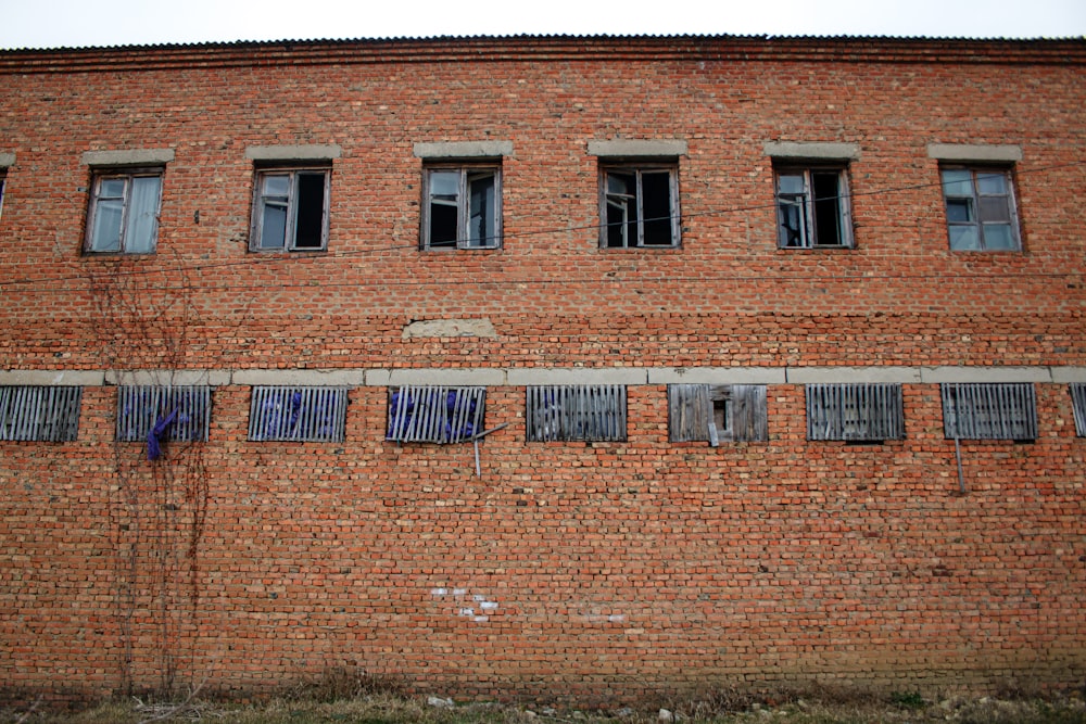 a red brick building with several windows and clothes hanging on a line