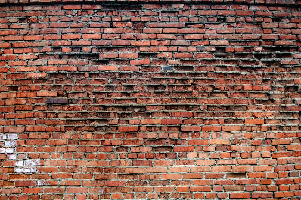 a red brick wall with graffiti on it
