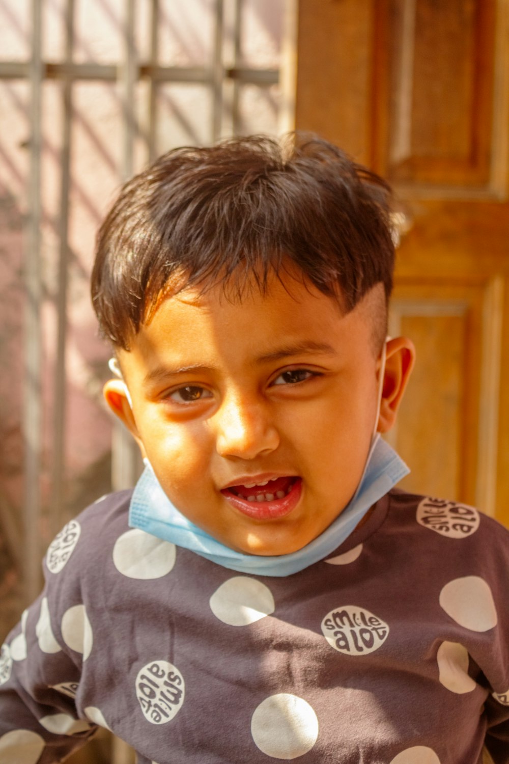 a young boy wearing a polka dot shirt