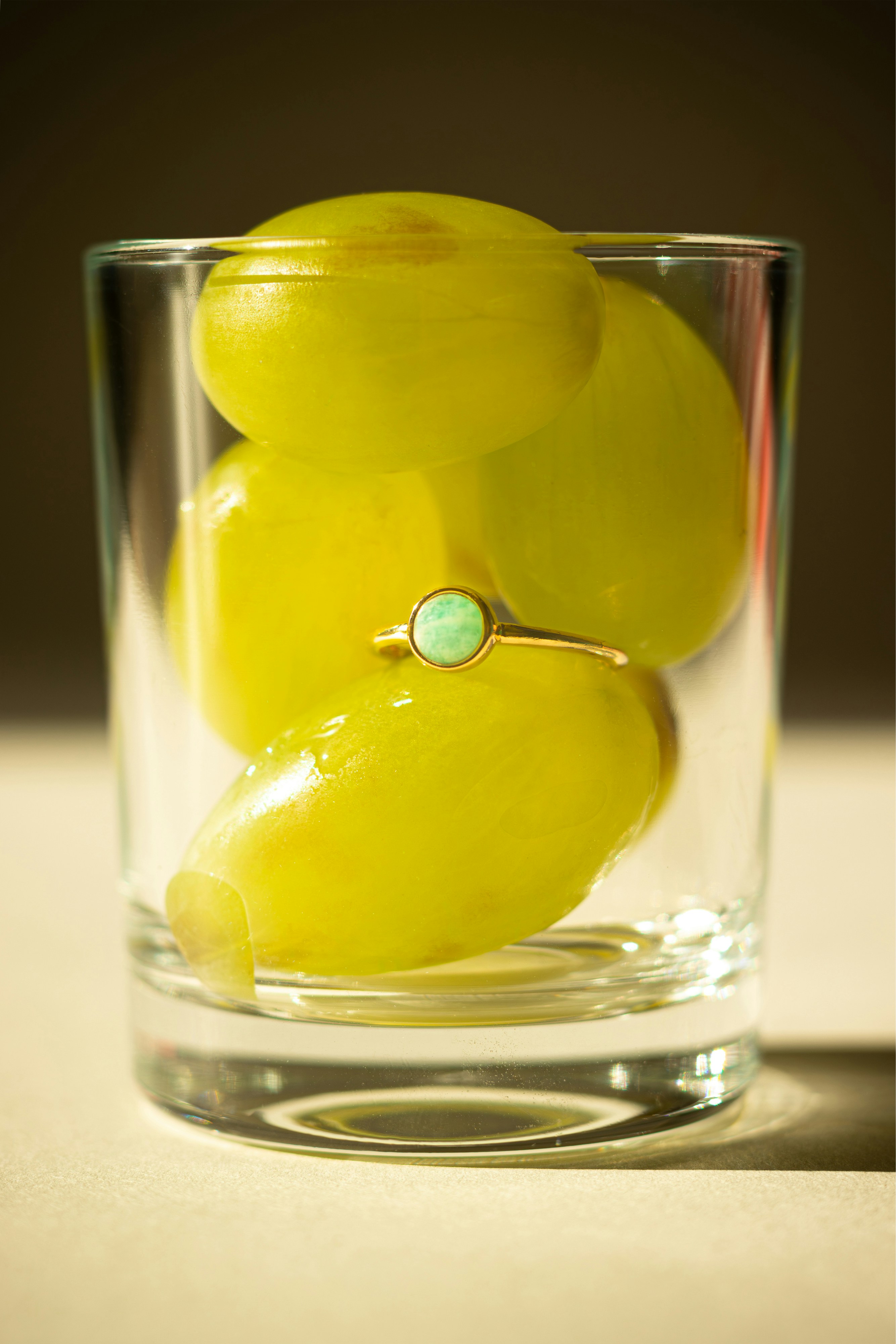 A glass filled with yellow fruit sitting on top of a table