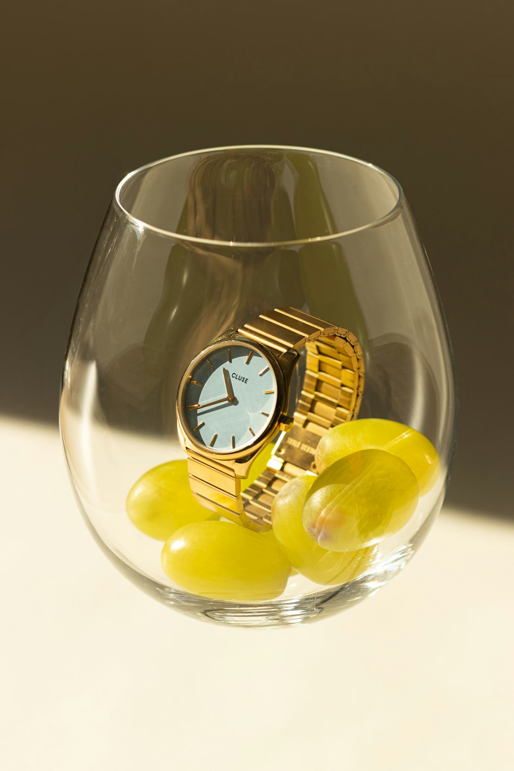 a gold watch sitting in a glass of water