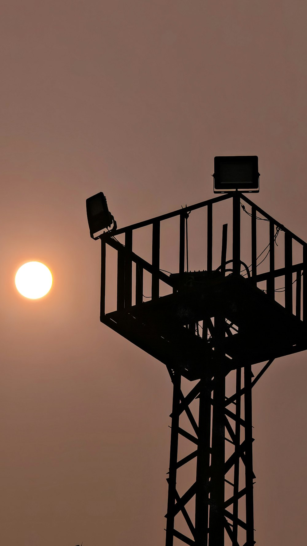 Die Sonne geht hinter einem hohen Turm unter