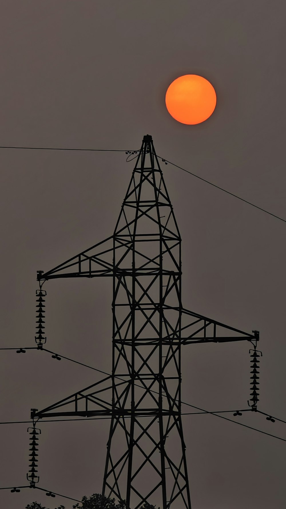 the sun is setting behind a power line