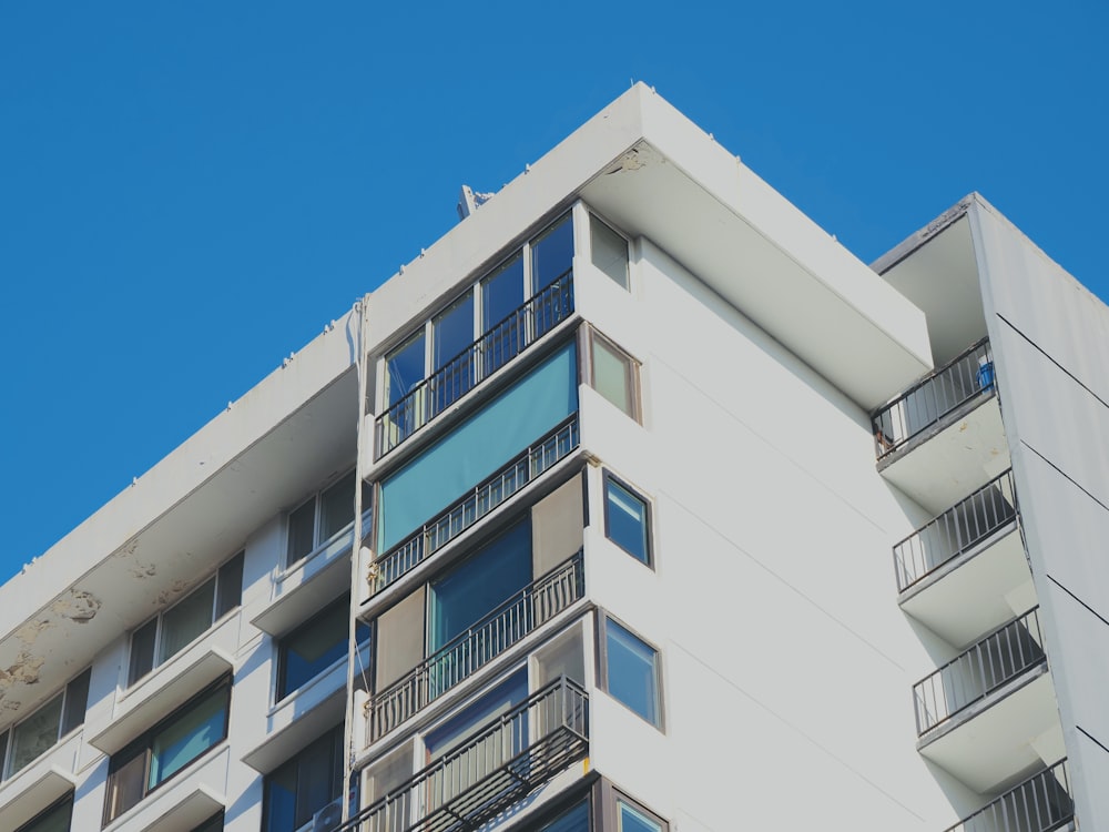 a tall white building with balconies and balconies