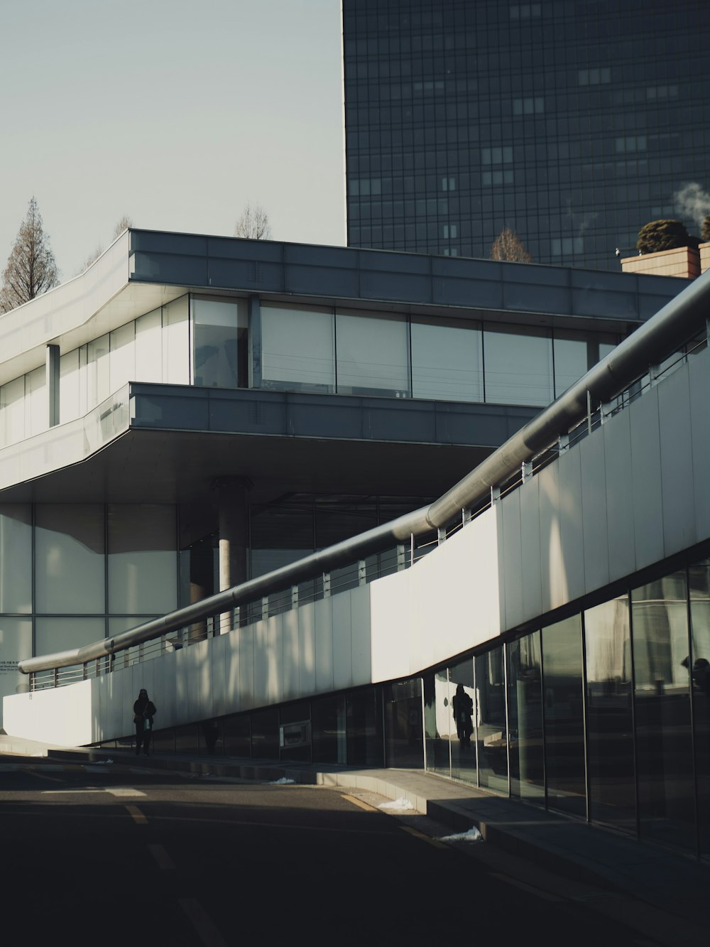 a man walking down a street next to a tall building