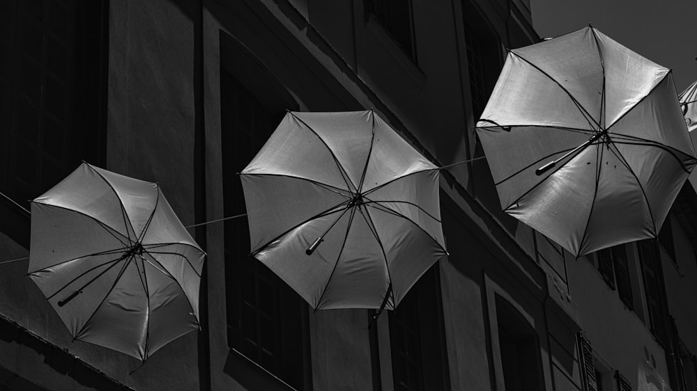 three umbrellas hanging from the side of a building
