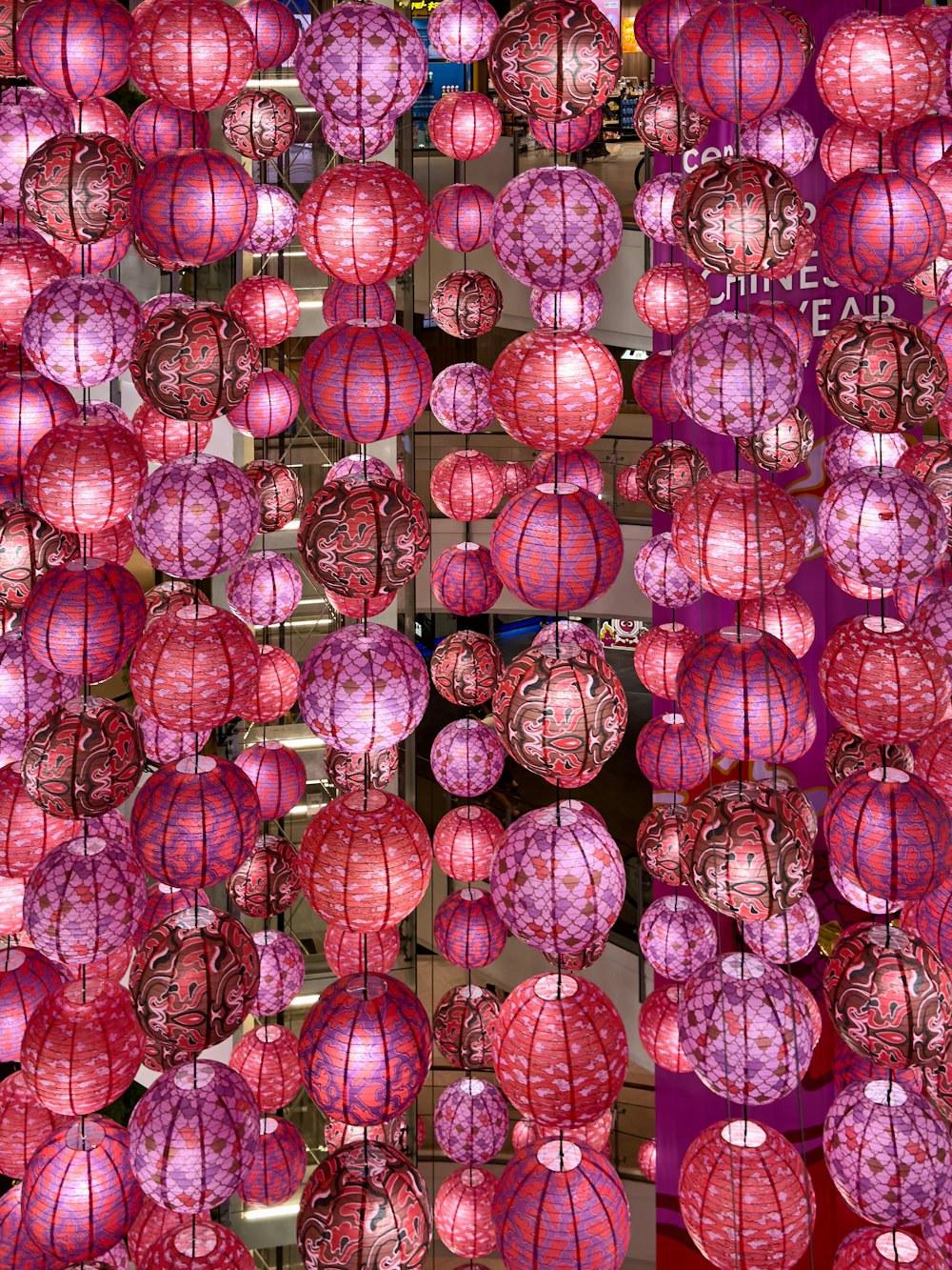 un bouquet de lanternes roses suspendues à un plafond