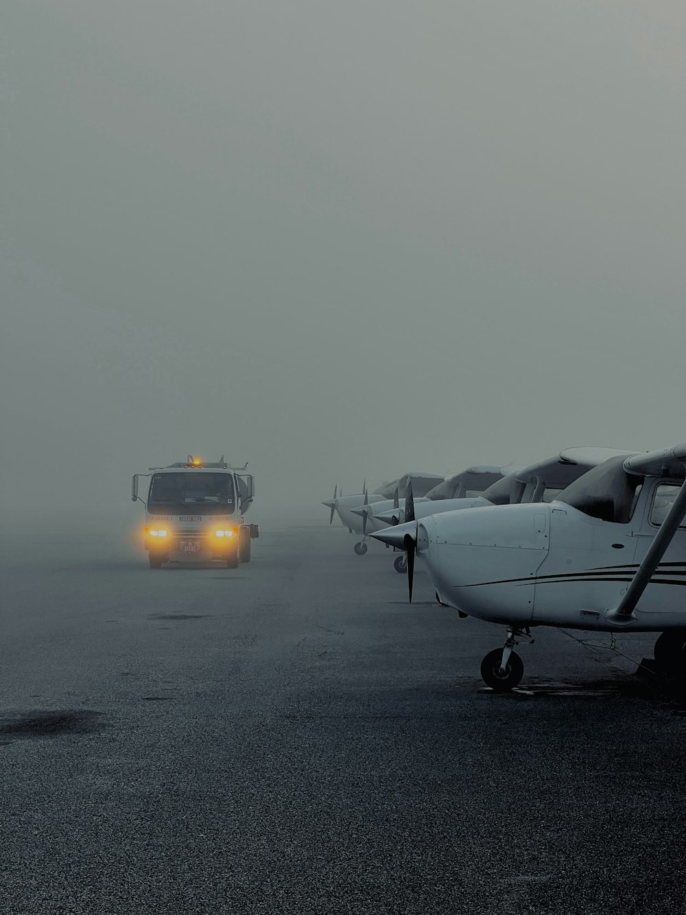 a couple of small planes sitting on top of an airport tarmac
